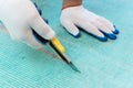 A worker is cutting a fiberglass mesh