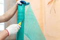 A worker is cutting a fiberglass mesh