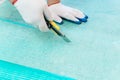 A worker is cutting a fiberglass mesh