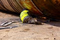 Worker is cutting old metal industrial equipment with acetylene torch