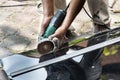 Worker cutting roof polycarbonate sheet with cutter tool