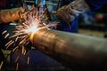 Worker cutting steel pipe with acetylene welding cutting torch a