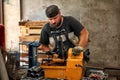 Worker cutting steel pipe with machine for threading