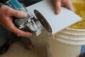 Worker cutting tile using grinder cut into layers of ceramic floor tiles Royalty Free Stock Photo