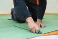 Worker cutting underlayment