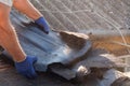 Worker demolishing old shingles to prepare a roof for a new installation. Royalty Free Stock Photo