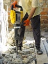 Worker with demolition hammer breaking interior wall