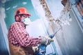 Worker with demolition hammer breaking interior wall Royalty Free Stock Photo