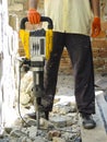 Worker with demolition hammer breaking interior wall
