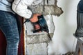 Worker with demolition hammer removing plaster from wall Royalty Free Stock Photo