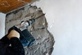 Worker with demolition hammer removing plaster from wall Royalty Free Stock Photo
