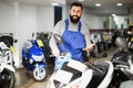 Worker demonstrating motorcycles and scooters Royalty Free Stock Photo