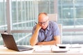 Middle aged man in hunched position at desk