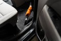 Worker of detailing service is using vacuum cleaner for remove dust and dirt in car. Vacuum cleaning of dirty car floor Royalty Free Stock Photo