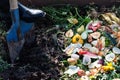 Worker digging compost box outdoors full with garden browns and greens and food  wastes Royalty Free Stock Photo