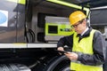 Worker with digital tablet operating construction machine