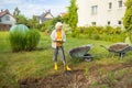 Worker digs the black soil with shovel in the vegetable garden, woman farmer loosens dirt in the farmland, agriculture Royalty Free Stock Photo