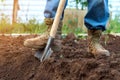 A worker digs the ground on a garden plot, a close-up of a shovel of a man`s feet Royalty Free Stock Photo