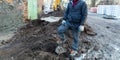 Worker in dirty uniform and shoes with orange laces is staying in the stone in construction site. Concept of diry and hard work