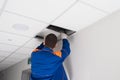 Worker dismantles the suspended ceiling, rear view Royalty Free Stock Photo