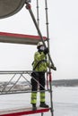 Worker dismantling temporary scaffolding wintertime