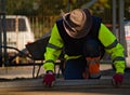 A paving man, equalizes the level of dry concrete as a foundation under the paving stones Royalty Free Stock Photo