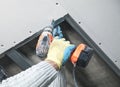 Worker with a drill screwdriver twists the screw into the drywall Royalty Free Stock Photo