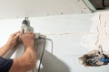 Worker with a drill screwdriver twists the screw into the drywall Royalty Free Stock Photo