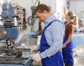 Worker drilling bores in glass on machine