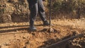 heavyduty boots press into packed earth, worker applies steady pressure with boots on tough ground as auger digs deep Royalty Free Stock Photo