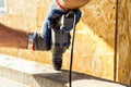 A worker drills a hole in a wooden bar with a drill on wooden. Wooden bar drilling with an electric drill. Construction Royalty Free Stock Photo