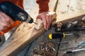 A worker drills a hole in wooden bar with drill Royalty Free Stock Photo