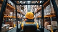 Worker operates forklift in large warehouse filled with stacked pallets during daytime hours Royalty Free Stock Photo