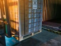 Worker driving forklift loading shipment carton boxes goods on wooden pallet at loading dock from container truck to warehouse car Royalty Free Stock Photo