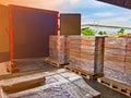Worker driving forklift loading shipment carton boxes goods on wooden pallet at loading dock from container truck to warehouse car Royalty Free Stock Photo
