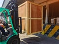 Worker driving forklift loading shipment carton boxes goods on wooden pallet at loading dock from container truck to warehouse car Royalty Free Stock Photo