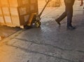 Worker driving forklift loading and unloading shipment carton boxes and goods on wooden pallet from container truck to warehouse c