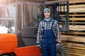 Worker driving forklift in lumber yard