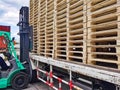 Worker driving forklift to loading and unloading wooden pallets from truck to warehouse cargo storage, shipment in logistics Royalty Free Stock Photo