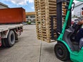 Worker driving forklift to loading and unloading wooden pallets from truck to warehouse cargo storage, shipment in logistics and Royalty Free Stock Photo