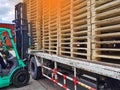 Worker driving forklift to loading and unloading wooden pallets from truck to warehouse cargo storage, shipment in logistics Royalty Free Stock Photo