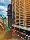 Worker driving forklift to loading and unloading wooden pallets from truck to warehouse cargo storage, shipment in logistics and t Royalty Free Stock Photo