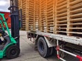 Worker driving forklift to loading and unloading wooden pallets from truck to warehouse cargo storage, shipment in logistics and t Royalty Free Stock Photo