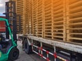 Worker driving forklift to loading and unloading wooden pallets from truck to warehouse cargo storage, shipment in logistics and t Royalty Free Stock Photo