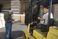 Worker Driving Forktruck And Senior Man Writing On The Clipboard Royalty Free Stock Photo