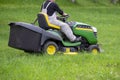 Worker driving lawn tractor mower