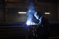 A worker electric welder cooks steel in a semi-automatic factory