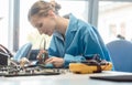 Worker in electronics manufacturing soldering a component