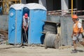 A worker is emptying ecological toilets on a construction site