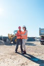 Worker and engineer on earthworks construction site planning